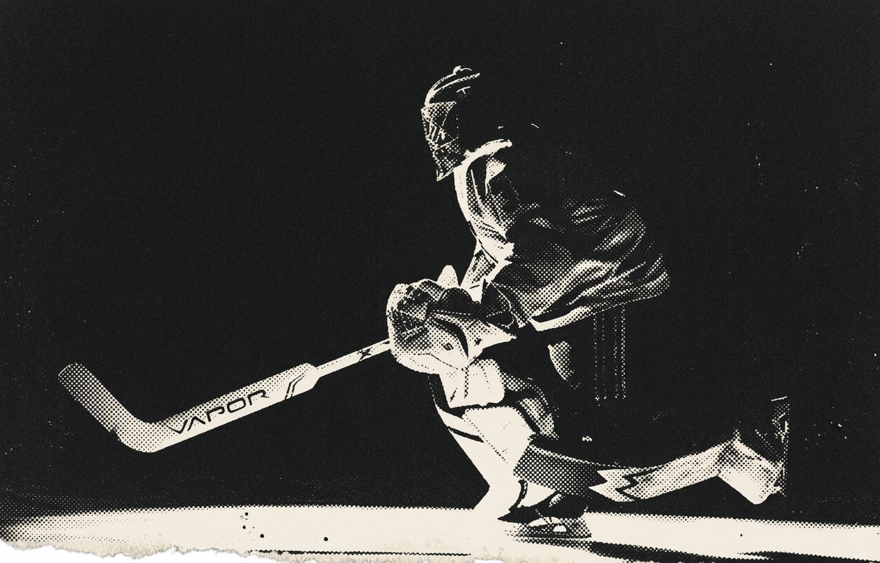 A goalie in his stance under a single light