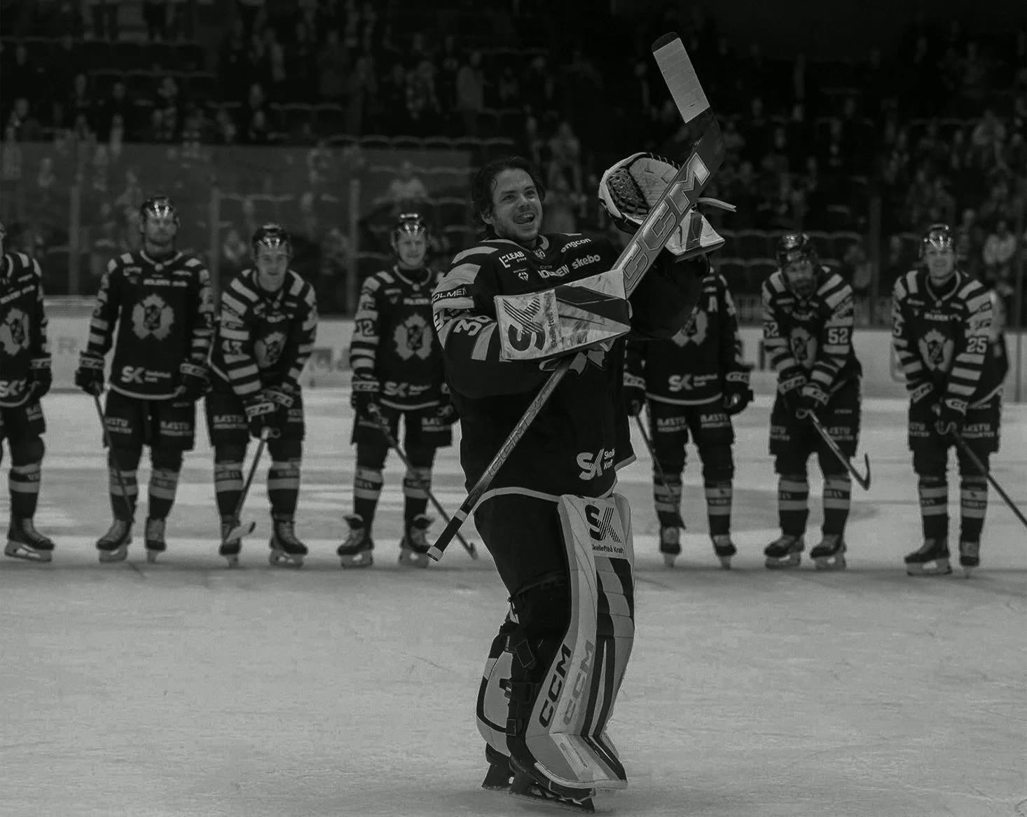 A team lined up as their goalie raises his stick
